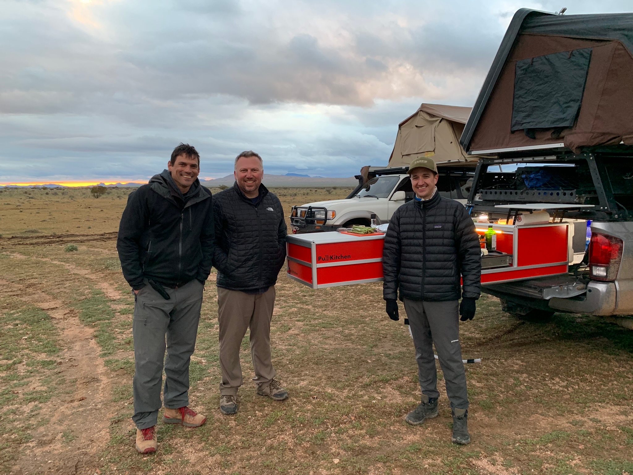 Dave Addington with fellow Overland Bound members standing around his truck.
