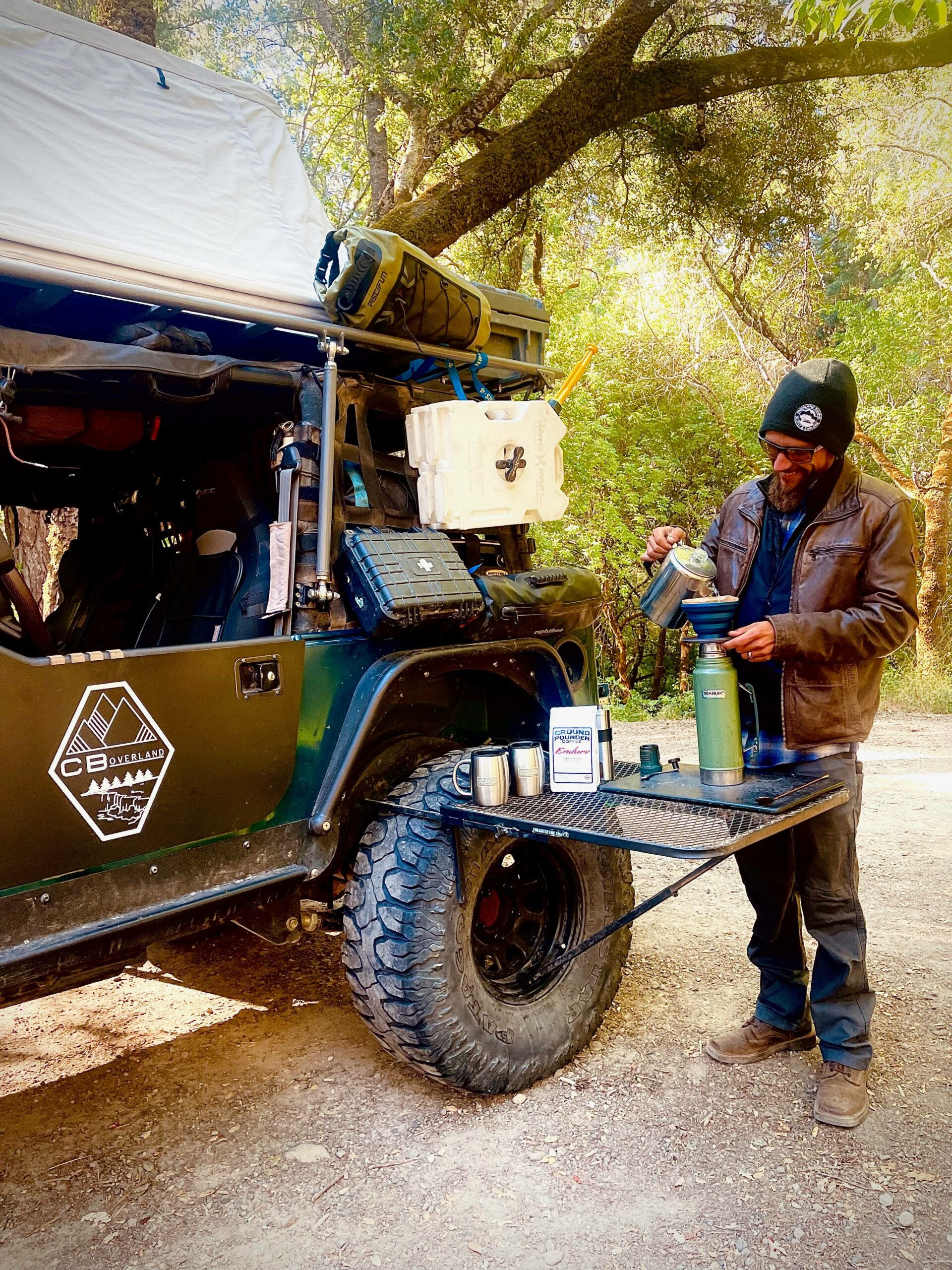 Blake pours coffee next to his overlanding jeep.