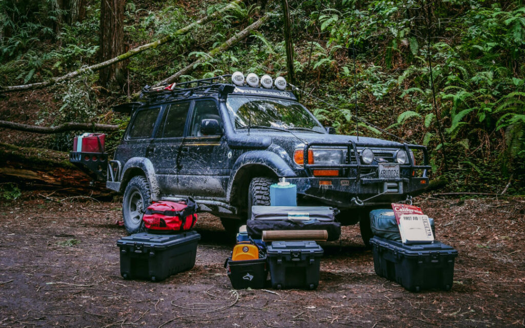 An FZJ80 is parked in the forest with gear